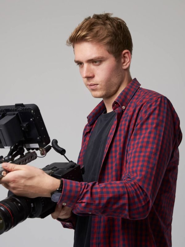 studio-portrait-of-male-videographer-with-film-camera.jpg